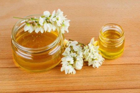 Foto de Flores de miel y flor de acacia sobre mesa de madera - Imagen libre de derechos
