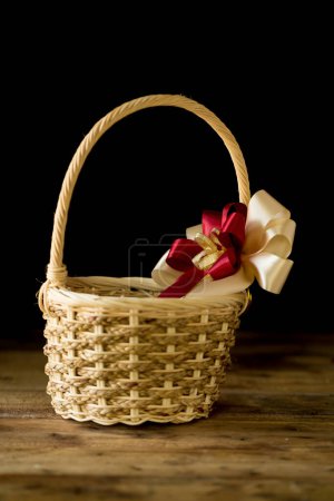 Photo for Closeup basket with bow on wooden table background - Royalty Free Image