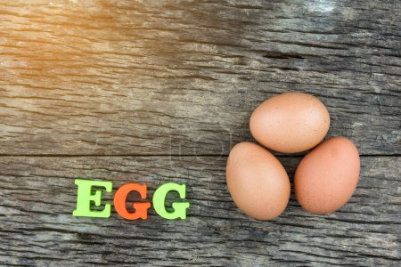 Photo for Three eggs on wooden table - Royalty Free Image