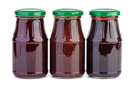 Foto de Tres frascos de vidrio con mermelada de fresa, cereza y grosellas negras - Imagen libre de derechos