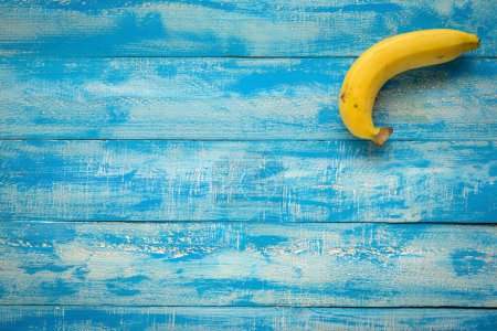 Téléchargez les photos : Bananes mûres sur une table en bois bleu vue dessus - en image libre de droit