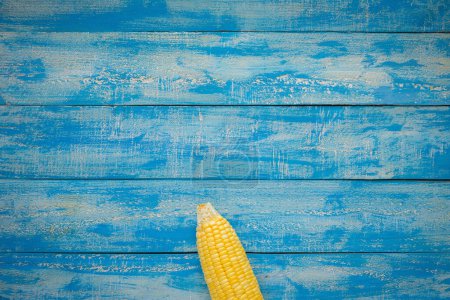 Photo for Ripe Corn on a blue wooden table top view - Royalty Free Image