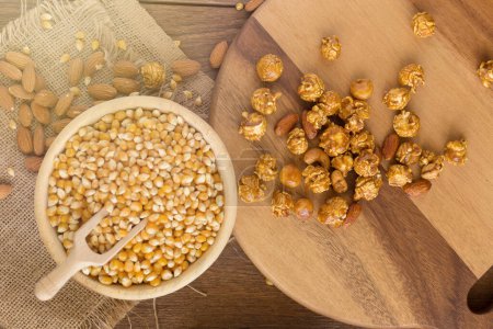 Photo for Corn kernels in wooden plates and popcorn with Caramel and almon - Royalty Free Image