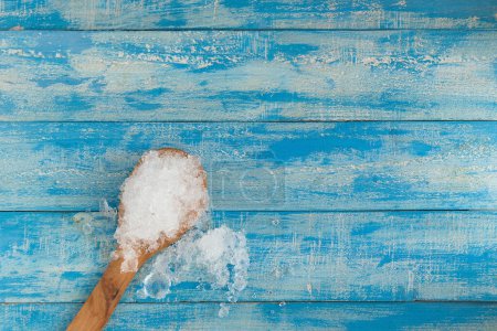 Photo for Crushed ice cubes and lemon, wooden spoon on vintage blue wooden - Royalty Free Image