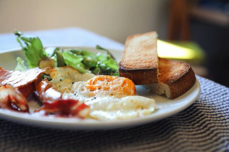 Téléchargez les photos : Petit déjeuner anglais œufs frits bacon saucisse pain et salade - en image libre de droit