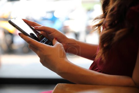 Téléchargez les photos : Main féminine avec smartphone trading stock en ligne dans le café - en image libre de droit