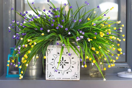 Foto de Flores artificiales decorativas en el alféizar de la ventana - Imagen libre de derechos