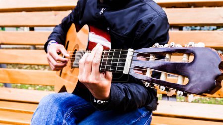 Photo for Musician playing guitar in public park - Royalty Free Image