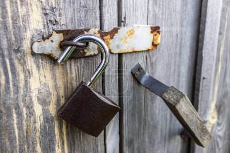 Téléchargez les photos : Un cadenas ouvert suspendu aux portes d'une ancienne grange en bois - en image libre de droit