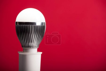 Photo for LED bulb in holder on red - Royalty Free Image
