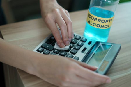 Foto de Female clean Calculator with Isopropyl alcohol for corona virus - Imagen libre de derechos