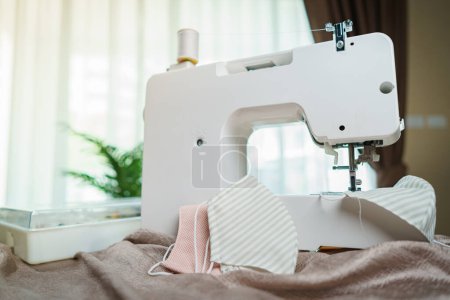 Photo for Fabrics and sewing machine for sewing an anti-virus face mask - Royalty Free Image