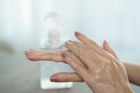 Téléchargez les photos : Mains féminines utilisant le distributeur de pompe de gel désinfectant pour les mains. - en image libre de droit