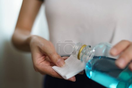 Téléchargez les photos : Pouring ethyl alcohol from bottle  into a cotton piece for coron - en image libre de droit