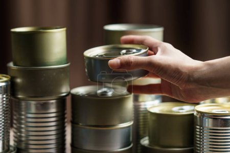Photo for Woman hand with group of Aluminium canned food. - Royalty Free Image