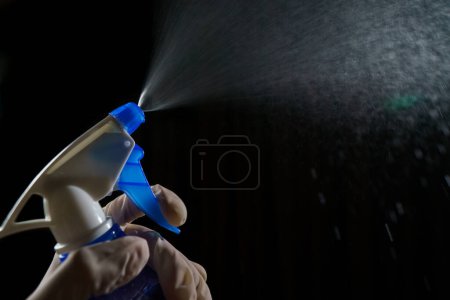 Foto de Mujer con desinfectante de pulverización brumosa azul para dejar de propagarse - Imagen libre de derechos