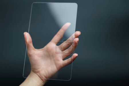 Téléchargez les photos : "Hand holding and showing transparent tablet device. Business, te" - en image libre de droit