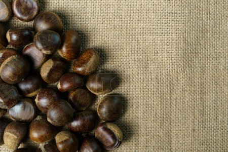 Photo for Roasted sweet chestnuts on rustic wooden table - Royalty Free Image