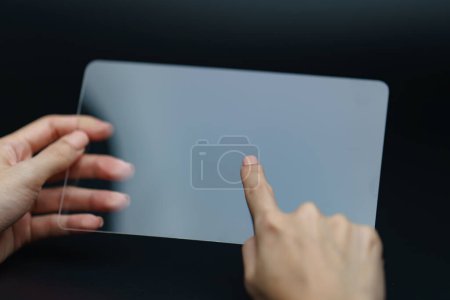 Foto de Mano sosteniendo y mostrando dispositivo de tableta transparente. Negocio - Imagen libre de derechos