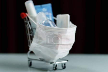 Téléchargez les photos : Shopping cart and sanitizer product with protective face mask - en image libre de droit