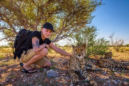 Foto de Turismo juega con dos guepardos - Imagen libre de derechos