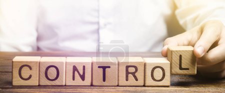 Photo for A man makes the word Control out of blocks. Business process management concept. Toughening monitoring. Manage staff and workers. Self-discipline and introspection. Leadership guidance - Royalty Free Image
