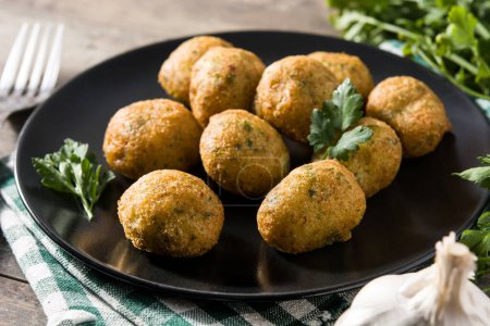 Photo for Traditional cod fritters decorated with garlic and parsley - Royalty Free Image