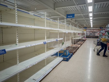 Foto de Una fila de estantes vacíos en un supermercado después de comprar pánico - Imagen libre de derechos