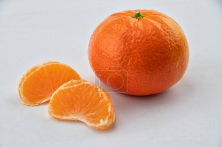 Foto de Fruta de clementina con dos segmentos de fruta sobre fondo blanco - Imagen libre de derechos