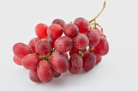 Foto de Racimo de uvas rojas sin semillas sobre fondo blanco - Imagen libre de derechos