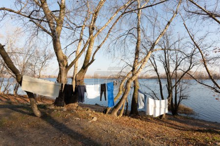 Foto de El secamiento de la ropa por el alambre, bajo el sol suave invernal, cerca del río - Imagen libre de derechos