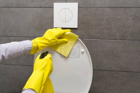 Foto de Hombre con guantes amarillos limpiando inodoro. concepto de limpieza del hogar. - Imagen libre de derechos