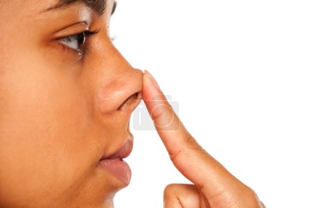 Téléchargez les photos : Femme à la peau foncée touchant son nez - en image libre de droit