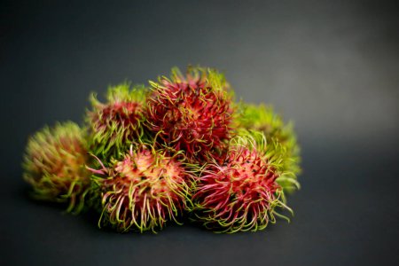 Téléchargez les photos : Rambutan Fruits sur fond noir - en image libre de droit