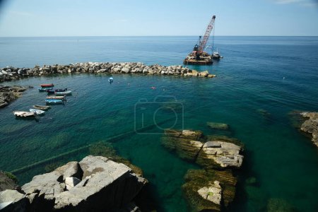 Photo for Barge with crane for dredging the seabed at the port of Riomaggi - Royalty Free Image