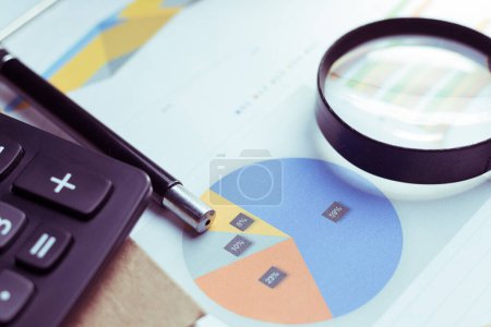 Photo for Business Analysis and Statistics Reports from sales charts last year using a magnifying glass - Royalty Free Image