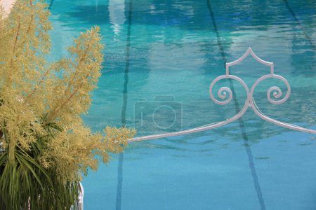 Photo for Swimming pool with blue water. Dracaena flower and  wrought iron - Royalty Free Image