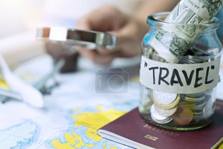 Foto de Ahorro de dinero en un frasco de vidrio para viajar en el mapa - Imagen libre de derechos