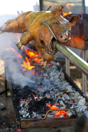 Photo for "Roast pig on a spit. Pig cooking in Germany" - Royalty Free Image