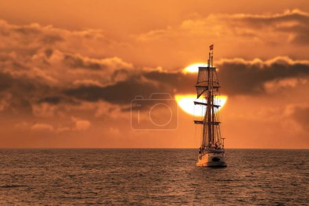Téléchargez les photos : Grand voilier antique, navire quittant le port de La Haye, Scheveningen sous un coucher de soleil chaud et un ciel doré - en image libre de droit