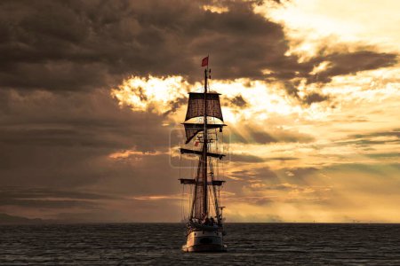 Foto de Barco alto antiguo, buque que sale del puerto de La Haya, Scheveningen bajo un cálido atardecer y un cielo dorado - Imagen libre de derechos