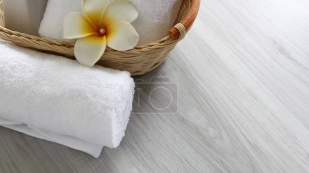 Téléchargez les photos : Beautifully folded white towels and toiletries. Place on a wooden table with a vase. - en image libre de droit