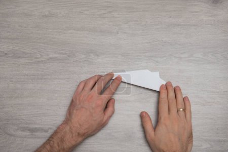 Téléchargez les photos : Comment faire origami avion en papier étape par étape instruction photo sur table en bois avec des bras. Étape 11 - en image libre de droit
