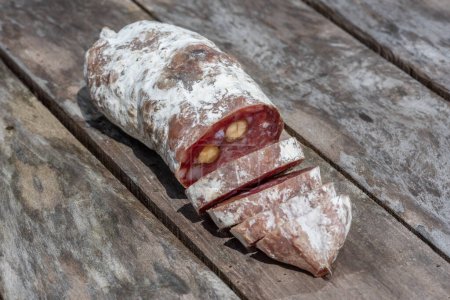 Téléchargez les photos : Saucisse séchée aux noix coupées en tranches - en image libre de droit