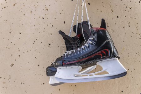 Photo for Winter sports skates hang on a wall as a symbol of career completion - Royalty Free Image