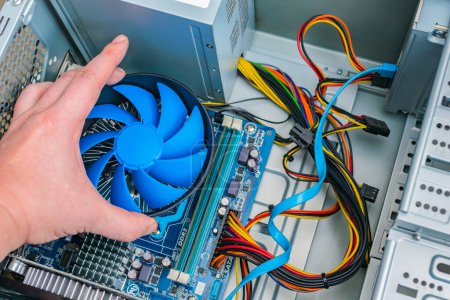 Photo for "Installing a processor fan on the computer motherboard. Computer repair, PC assembly" - Royalty Free Image