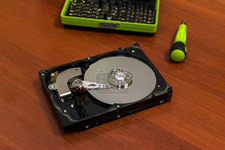 Foto de El disco duro del ordenador en el tipo desmontado se encuentra sobre la mesa a la reparación - Imagen libre de derechos