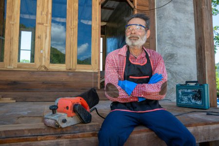 Téléchargez les photos : Vieux menuisier travaillant dans un atelier de menuiserie - en image libre de droit