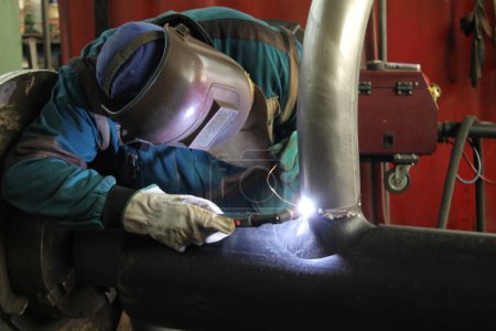 Foto de Soldador que trabaja con acero en la fábrica industrial - Imagen libre de derechos