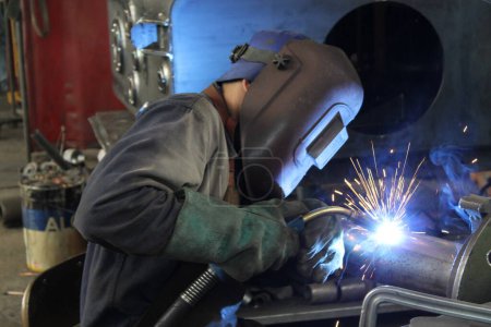 Téléchargez les photos : Soudeur travaillant avec l'acier à l'usine industrielle - en image libre de droit